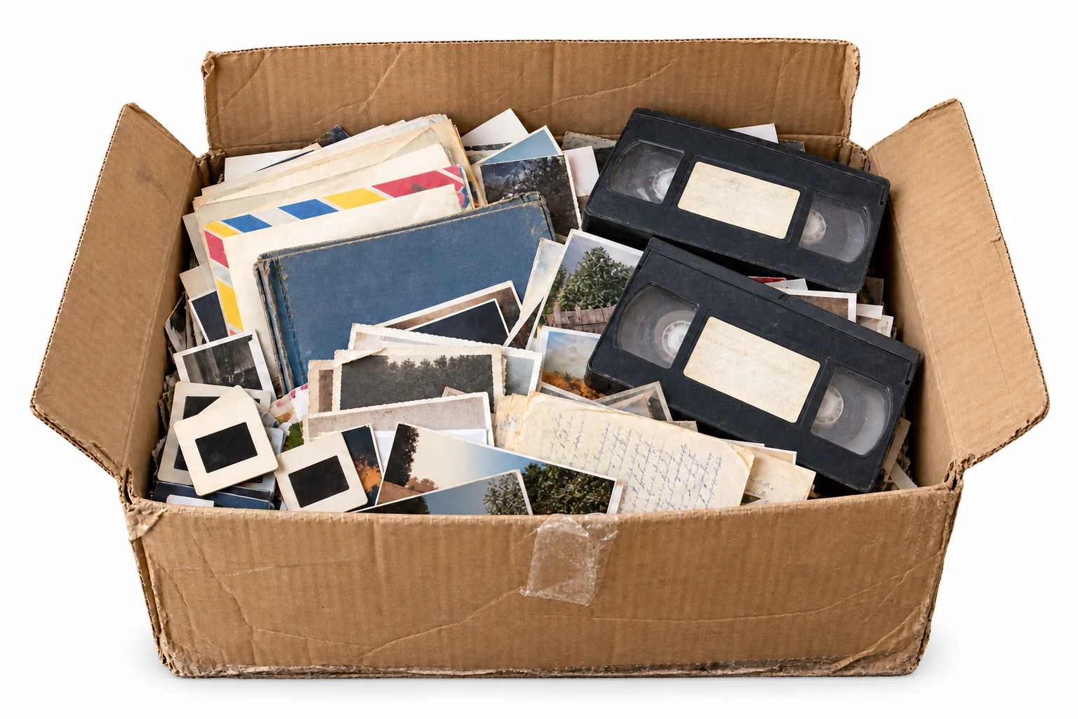 A cardboard box filled with photographs and home-video tapes
